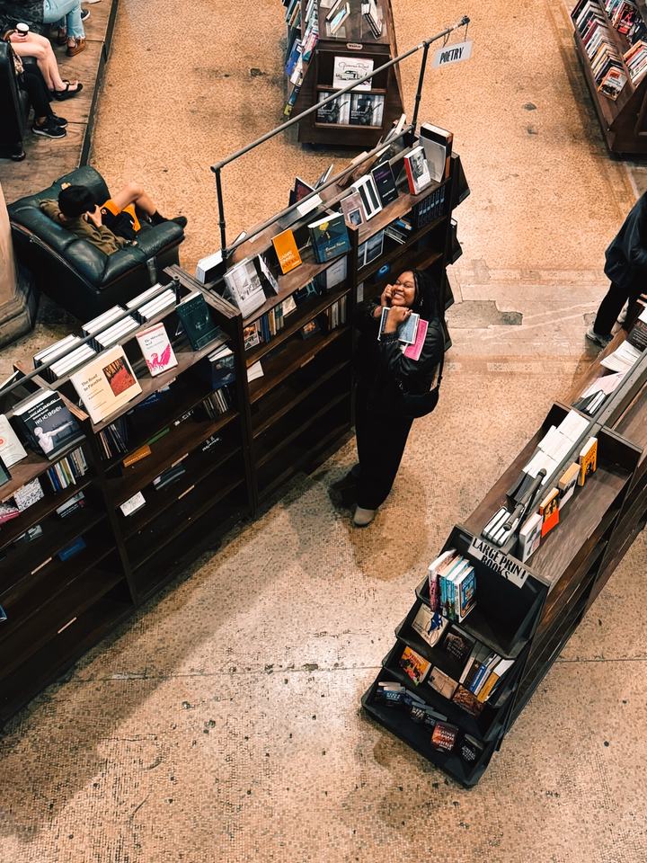 Rachel holding books in a bookshop
